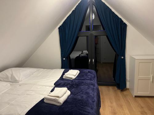 a bedroom with a bed with two towels on it at Domki nad morzem " Przy Lesie" in Kopalino