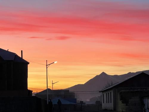 a sunset in a city with mountains in the background at Omar’s place in Ölgiy