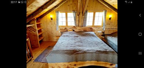 ein Schlafzimmer mit einem Bett in einer Holzhütte in der Unterkunft Naturstammhaus Pauker in Klagenfurt am Wörthersee