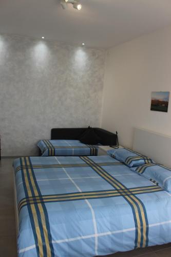 Schlafzimmer mit einem Bett mit blauer und gelber Bettwäsche in der Unterkunft B&B Fili d'erba in Farra dʼlsonzo