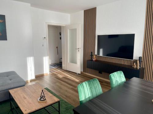 a living room with a table and a tv at HP Apartment 3-Zi-Whg - 69qm, 6 Pers, Balkon, Wifi, Küche, Bad in Hannover