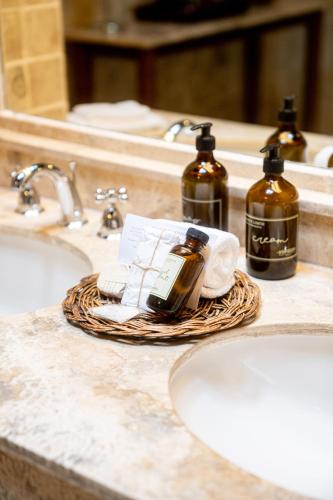 a bathroom counter with two bottles of soap and towels at Inkaterra Machu Picchu Pueblo Hotel in Machu Picchu