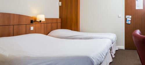 Una cama o camas en una habitación de Kyriad Montargis Amilly
