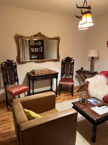 a living room with a couch and chairs and a mirror at Engelsherz in Mittenwald
