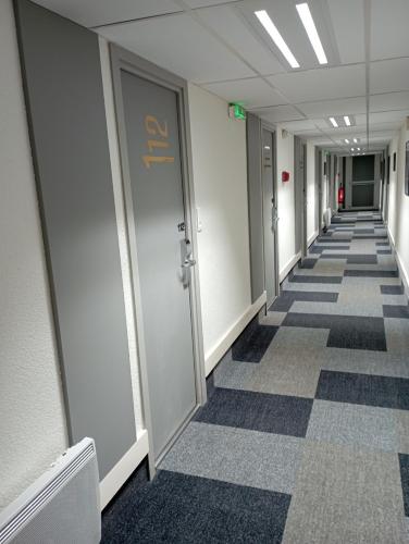 an empty hallway in an office building with ailed floor at ibis les Etangs des Moines in Fourmies