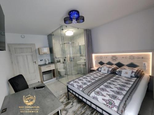 a bedroom with a bed and a shower and a table at Szczawnica Residence "Nad Zdrojami" - In the Heart of Recreation 691-739-603 in Szczawnica