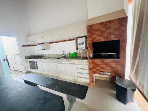 a kitchen with white cabinets and a black bench in it at Casa para temporada Caldas Novas-GO Brasil in Caldas Novas
