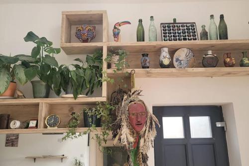 a room with wooden shelves with vases and a door at Heart of Easton in Bristol