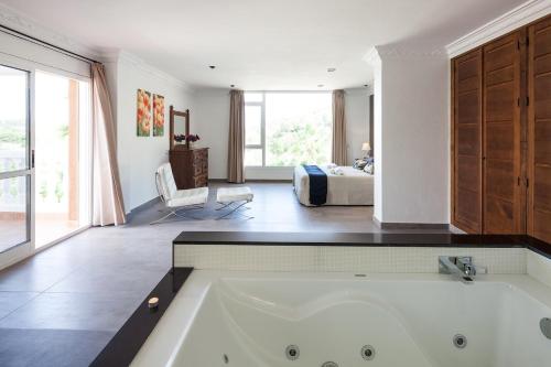a bath tub in a room with a bedroom at Villa Solaris in Sant Jordi