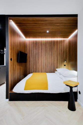 - une chambre avec un lit et un mur en bois dans l'établissement Le Bijou de Poincaré - Centre Gare, à Nancy