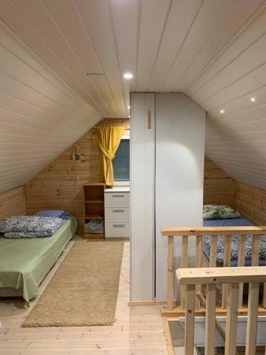 pokój z dwoma łóżkami i schodami w domu w obiekcie Villa Kuuhimon Helmi w mieście Parkano