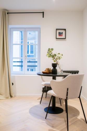 une table et une chaise dans une pièce avec une fenêtre dans l'établissement Le Bijou de Poincaré - Centre Gare, à Nancy