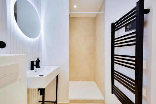 une salle de bain avec un lavabo et un miroir dans l'établissement Le Bijou de Poincaré - Centre Gare, à Nancy