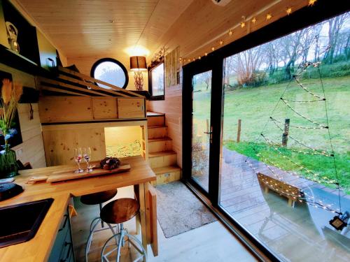 a kitchen in a tiny house with a large window at La mini maison du Lama in Libin