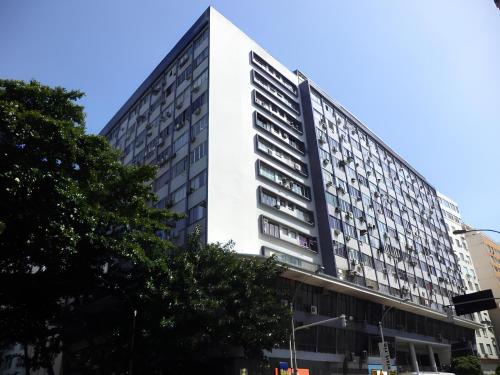 un edificio blanco alto en una calle de la ciudad en Apartamento Studio completo Copacabana 1 quadra da praia com garagem, en Río de Janeiro