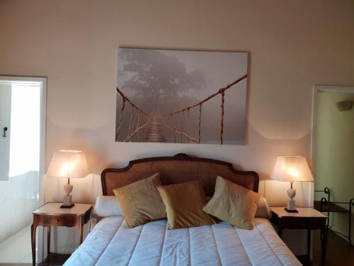 a bedroom with a bed with a bridge painting on the wall at Casa de Campo - Cinfães do Douro in Cinfães