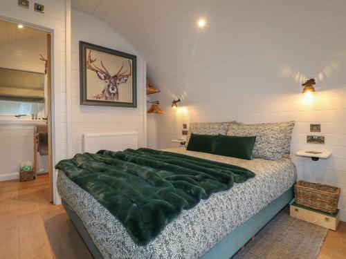a bedroom with a large green blanket on a bed at Oh Deer in Ashbourne