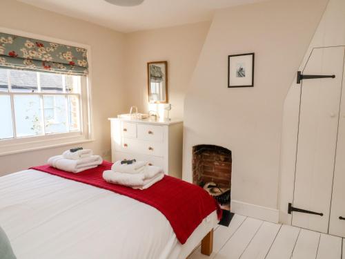 a bedroom with a bed and a fireplace at Shrimpers Cottage, Aldeburgh in Aldeburgh