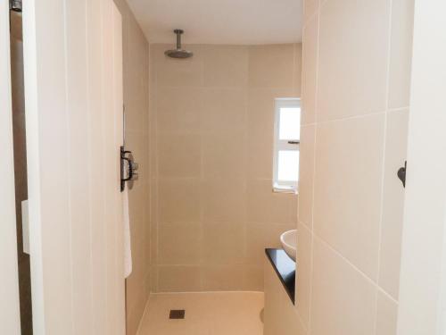 uma casa de banho com um chuveiro, um WC e um lavatório. em Shrimpers Cottage, Aldeburgh em Aldeburgh