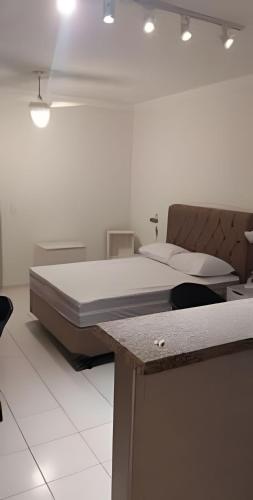 a bedroom with a bed and a table with chairs at Edifício Belluno in Ribeirão Preto