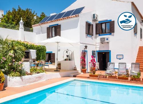 a villa with a swimming pool in front of a house at Villa Marrakech by Algarve Vacation in Carvoeiro