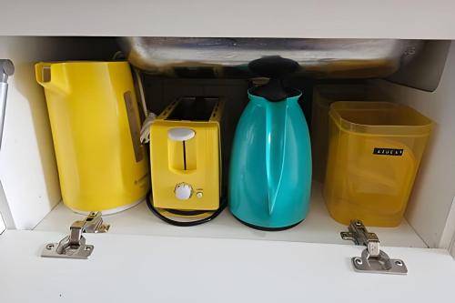 a shelf with four containers and a blue vase at Edíficio Sienna in Ribeirão Preto