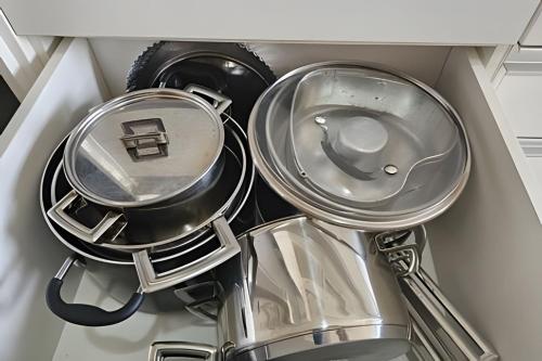 a pile of pans and utensils in a drawer at Edíficio Sienna in Ribeirão Preto