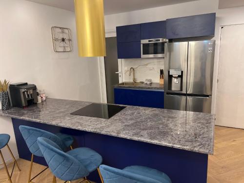 a kitchen with blue cabinets and stainless steel appliances at Luxury apartment with sea view in Marseille