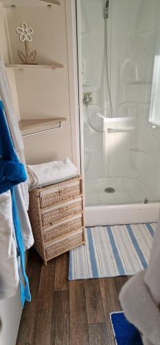 baño con ducha y cestas de mimbre en el suelo en Mobilhome 4/5 personnes, en Longeville-sur-Mer