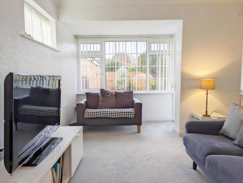a living room with a couch and a tv at Marine Lodge in Bognor Regis