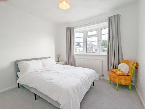 a bedroom with a bed and a window and a chair at Marine Lodge in Bognor Regis