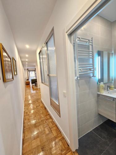 a hallway with a bathroom with a sink and a mirror at MAD COCO Apartamento Frente al Prado in Madrid