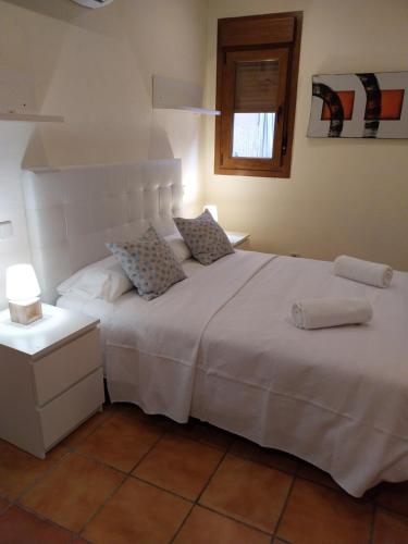 1 dormitorio con 1 cama blanca grande y 2 almohadas en CASONA 44, en Alcalá de Henares
