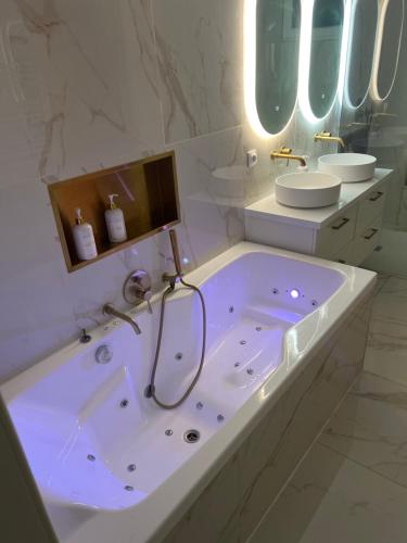 a large white bathroom with a tub and a sink at Luxury apartment with sea view in Marseille