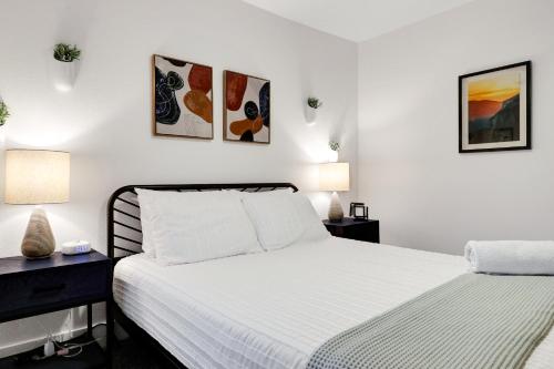 a white bedroom with two beds and two lamps at Artsy - A Birdy Vacation Rental in San Antonio