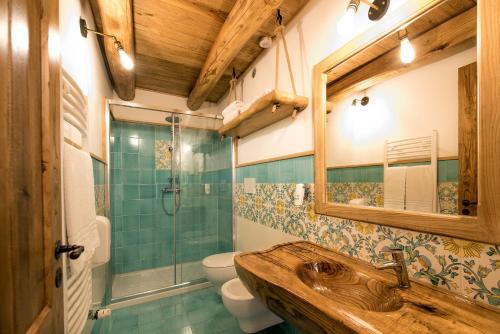 a bathroom with a sink and a toilet and a mirror at Etna Quota Mille Boutique Hotel, Typical Sicilian Food & Wine in Randazzo