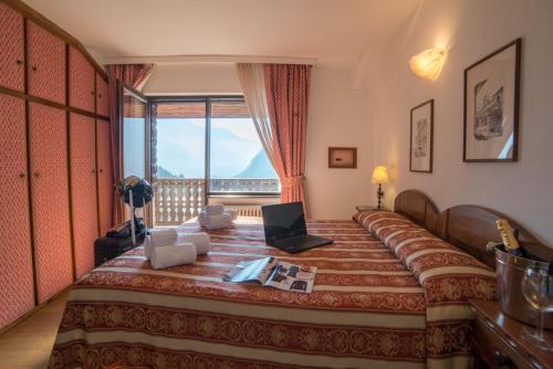 sypialnia z łóżkiem z laptopem w obiekcie HG Hotel Italia w mieście Brusson