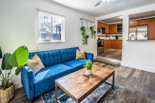 a living room with a blue couch and a wooden table at 2 BD Home w/ Private Parking, Private Yard & W/D in Miami