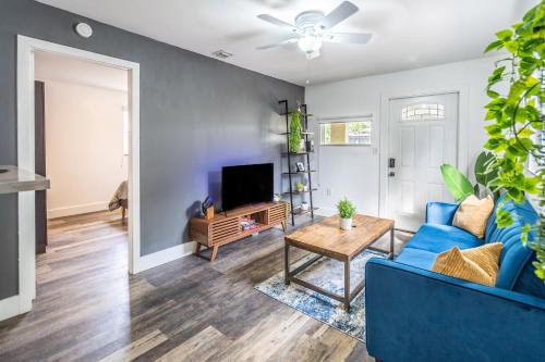 a living room with a blue couch and a tv at 2 BD Home w/ Private Parking, Private Yard & W/D in Miami