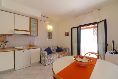a kitchen and living room with a table and a couch at Rif. B16 - MEDITERRANEO in San Vincenzo