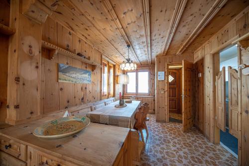 drewniany pokój z łóżkiem i stołem w obiekcie Apartments & Rooms MyHolidayLivigno w Livigno