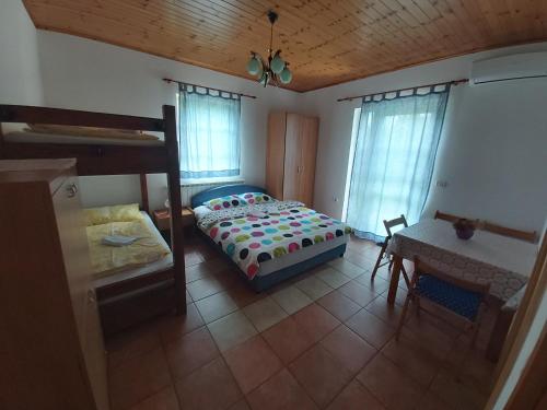 1 dormitorio con cama, escritorio y mesa en Apartma Brešan, en Kobarid