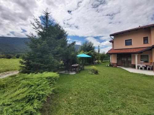 a house with a yard with a table and chairs at Apartma Brešan in Kobarid