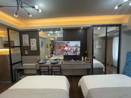 Cette chambre comprend 2 lits et une télévision. dans l'établissement Cozy Family Nook at Makati, à Manille