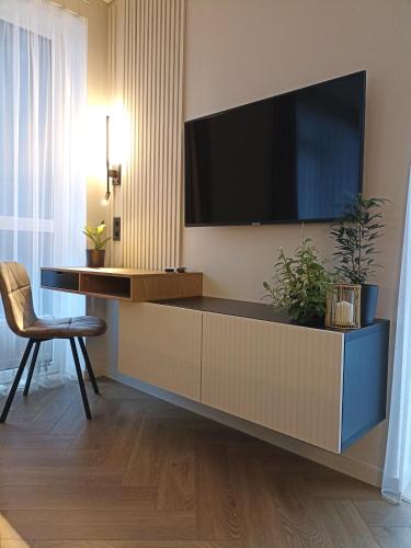 a living room with a tv on a wall at Apartments with a balcony and an impressive terrace on the roof of the house - PRIVATE FREE CAR PARKING in Vilnius