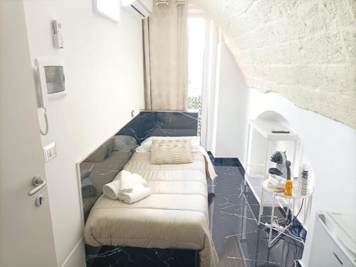 モドゥーニョにあるNewhouse Rooms BLACK & WHITEの小さな部屋で、角にベッドが1台あります。