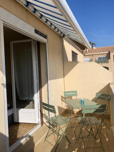 a patio with a table and chairs on a balcony at Appartement charmant à Fleury - 30 m² - Vue sur la mer in Fleury