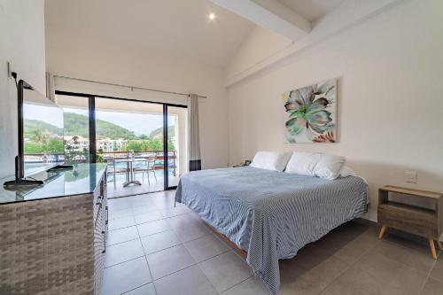 a bedroom with a bed and a balcony at 3027 - Santa Cruz Condo in Santa Cruz Huatulco