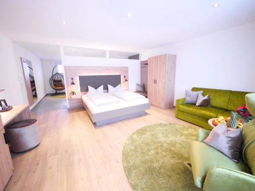 un soggiorno con un letto e un divano di Berghotel Zollersteighof ad Albstadt