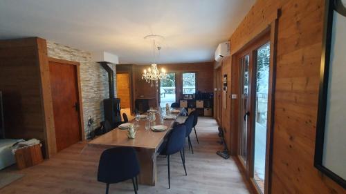 a dining room with a long table and chairs at Chalet Le Dahu in La Bresse